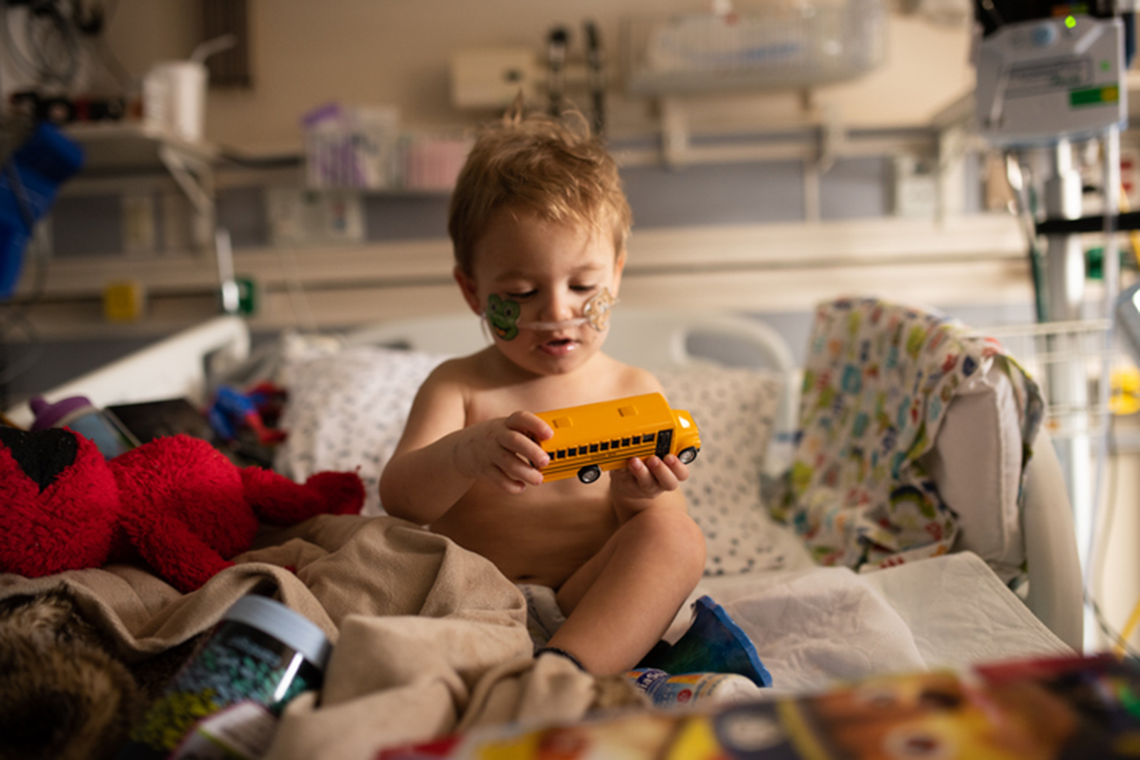 Child playing with school bus toy in bedroom