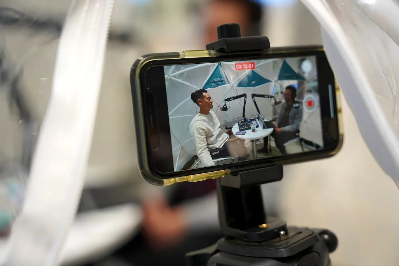 A phone recording an interview featuring Albert Jame