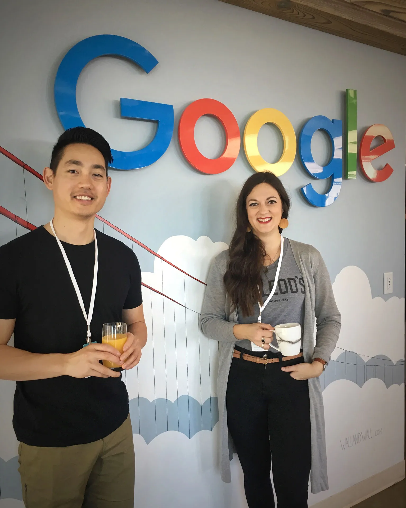 Albert Jame smiling beside a smiling lady with a Google logo in the background