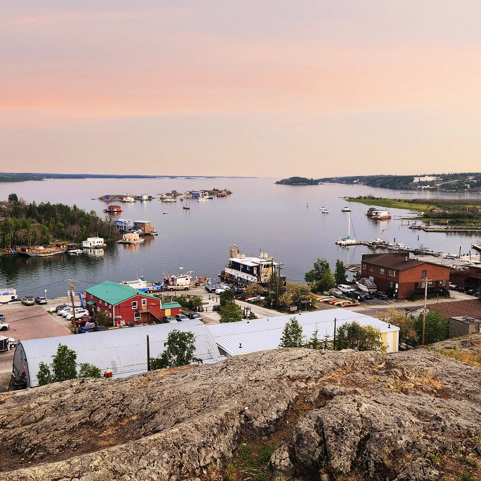 View of Yellowknife’s Old Town waterfront on Great Slave Lake at sunset with houseboats and docks