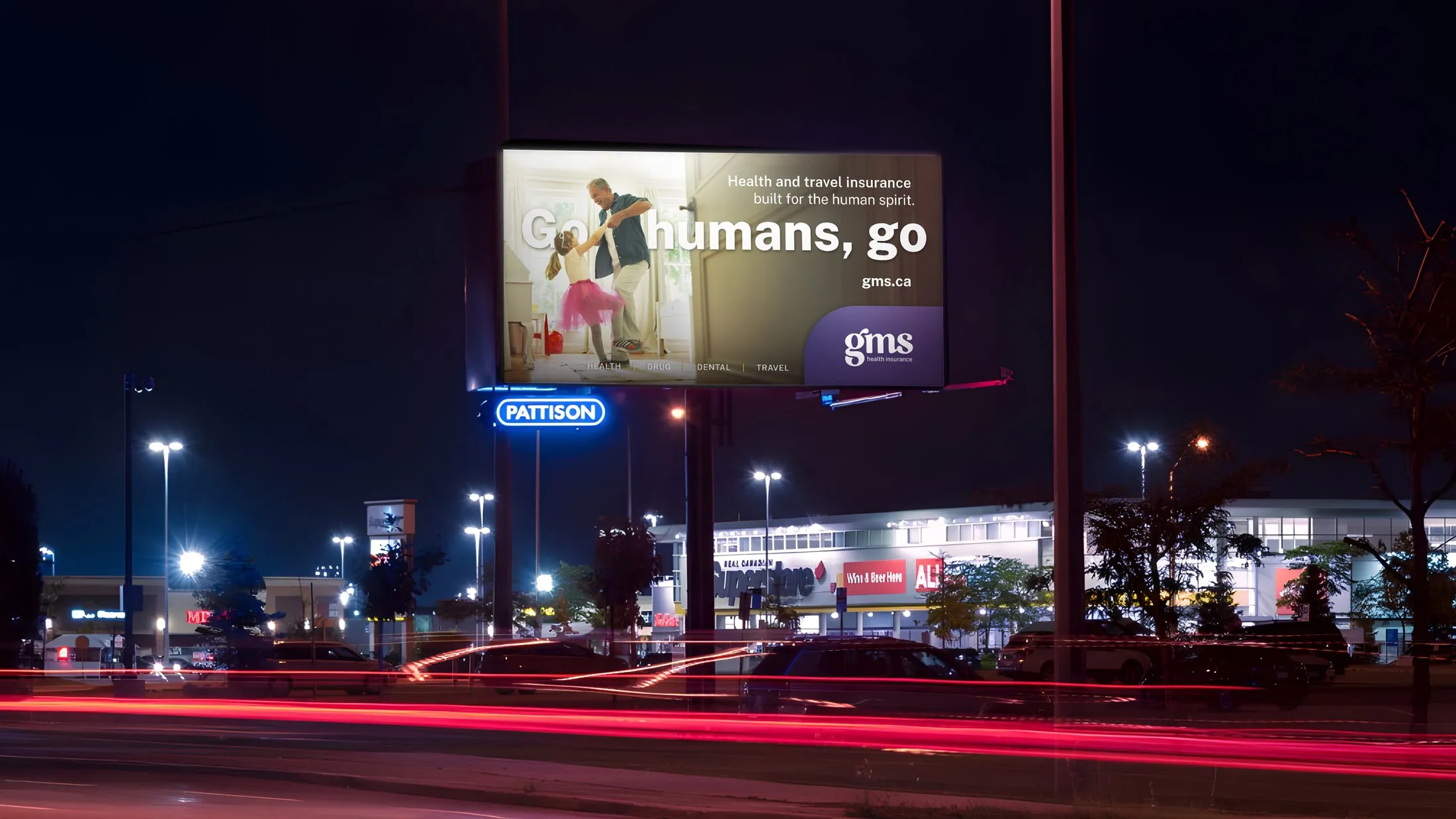 Nighttime roadside billboard featuring GMS Go humans, go campaign ad