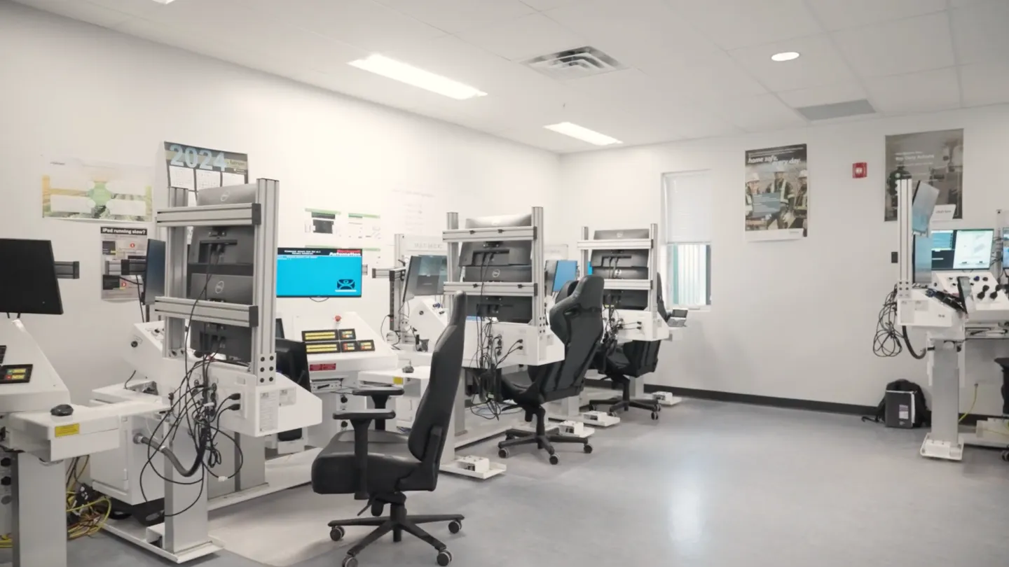 An image of an operator control room with devices and chairs.