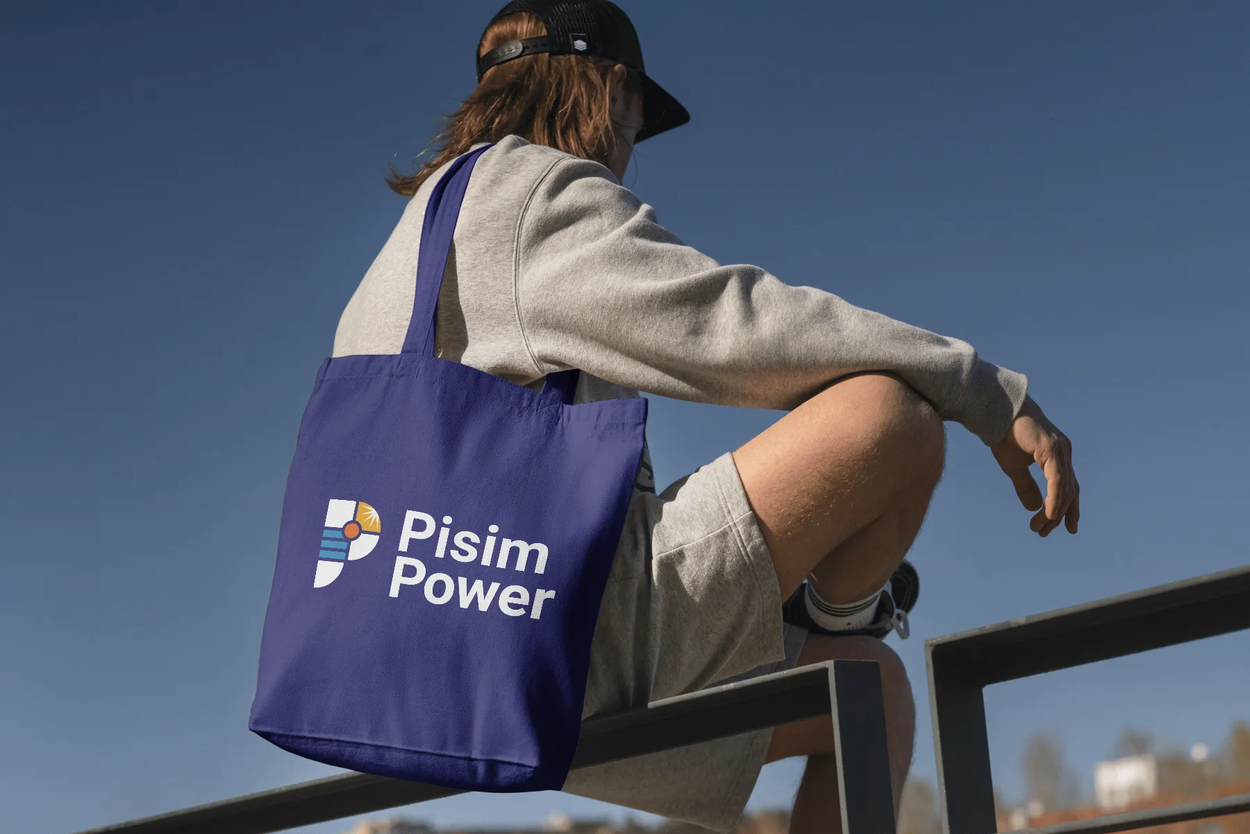 Person sitting with a Pisim Power branded bag