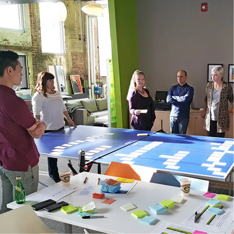 Team workshop with participants arranging content cards on blue planning boards