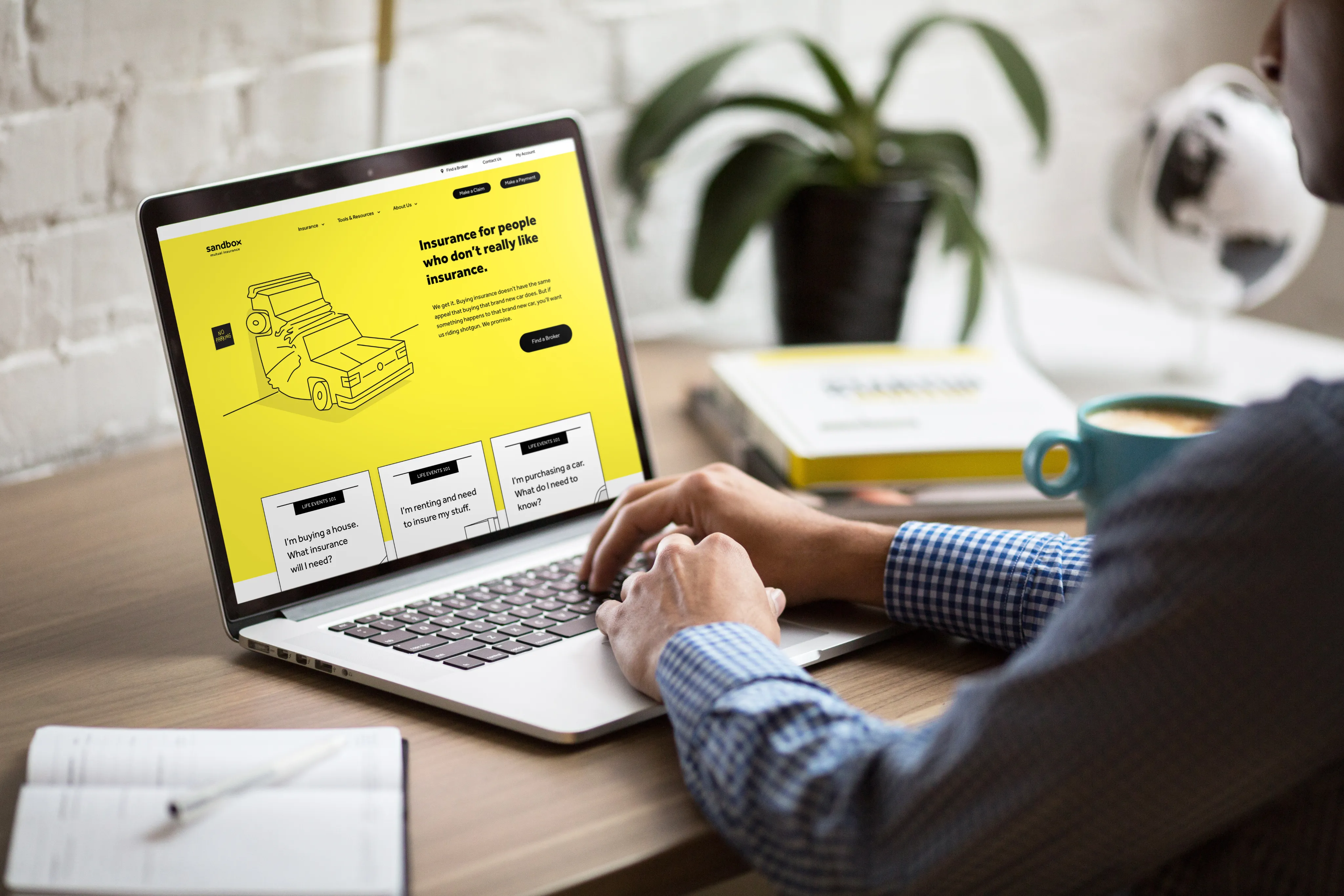 Person using a laptop with the Sandbox homepage on screen